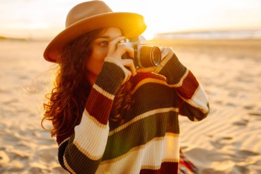 Plajda Vintage Camera 'lı genç bir kadın. Piknik, rahatla, hafta sonu.