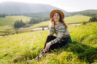 Sırt çantalı bir kadın turist dağlarda rahatça dolaşır. Gezgin doğanın tadını çıkarıyor. Maceralar.