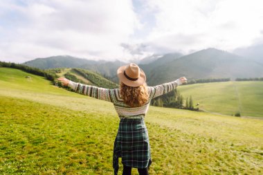 Sırt çantalı bir kadın turist dağlarda rahatça dolaşır. Gezgin doğanın tadını çıkarıyor. Maceralar.