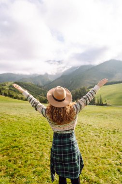 Sırt çantalı bir kadın turist dağlarda rahatça dolaşır. Gezgin doğanın tadını çıkarıyor. Maceralar.