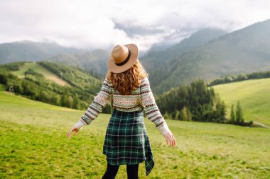 Sırt çantalı bir kadın turist dağlarda rahatça dolaşır. Gezgin doğanın tadını çıkarıyor. Maceralar.
