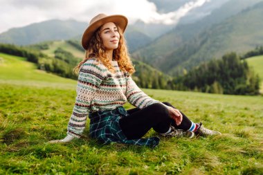 Sırt çantalı bir kadın turist dağlarda rahatça dolaşır. Gezgin doğanın tadını çıkarıyor. Maceralar.