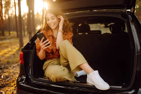 Wanita Muda Duduk Bagasi Mobil Dan Menggunakan Smartphone Konsep Bepergian — Stok Foto