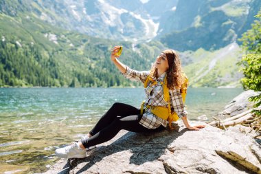 İyi turistler yürüyüş yapar ve akıllı telefon kamerasıyla selfie çeker. Yaşam tarzı, seyahat, turizm, aktif yaşam.