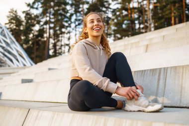 Spor kıyafetli genç bir kadın sabahları dışarıda egzersiz yapıyor. Spor, aktif yaşam, spor eğitimi, sağlıklı yaşam tarzı..