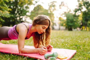 Yoga yapan genç bir kadın, parkta spor egzersizleri. Sağlıklı spor yaşam tarzı.