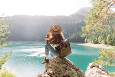 Maceracı kadın, dağların, ormanın ve gölün arasında mutlu hissederek doğanın tadını çıkarıyor. Yaşam tarzı, gezgin, doğa, aktif yaşam.