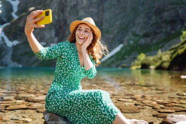 Seyahat ederken selfie. Mutlu kadın yürüyor ve akıllı telefon kamerasıyla selfie çekiyor. Yaşam tarzı, seyahat, turizm, aktif yaşam.