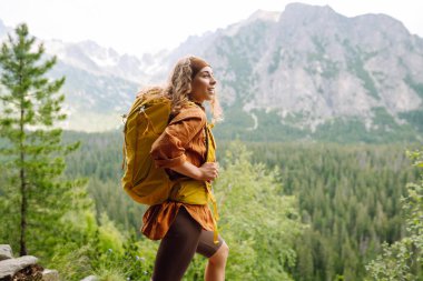 Kadın gezgin dağların güzel manzarasının tadını çıkarıyor. Güzel dağlar manzara. Yaşam tarzı, macera, doğa, aktif yaşam.