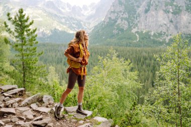 Kadın gezgin dağların güzel manzarasının tadını çıkarıyor. Güzel dağlar manzara. Yaşam tarzı, macera, doğa, aktif yaşam.