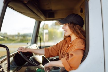 Büyük bir kamyon süren profesyonel bir kadının portresi. Aracın içinde. Kadın bir kamyoncu. Halk ve endüstriyel ulaşım kavramı.