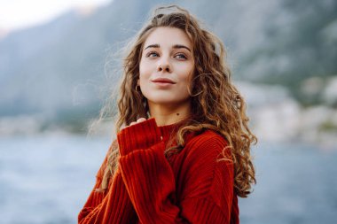 Rüzgarlı bir günde güzel bir kıvırcık kadının portresi. Seyahat, moda, rahatlama ve yaşam tarzı konsepti.