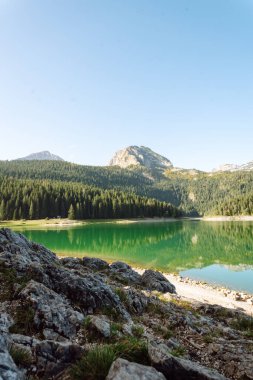 Göl manzarası çok güzel. Sabah Dağ Gölü 'nün kayalık kıyısı. Seyahat, yaşam tarzı, vahşi doğa konsepti. Seyahat için ünlü bir yer.