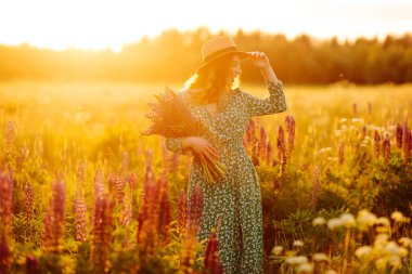 Yaz günü lavanta tarlasında genç bir kadın. Çiçek açan lavanta tarlası. Doğa, rahatla, seyahat ve yaşam tarzı.