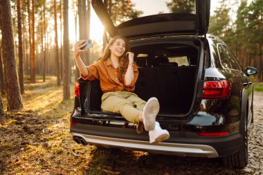 Arabayla seyahat ederken selfie. Video aracılığıyla mutlu turist sohbetleri ya da arabanın arka koltuğunda selfie çekmeler. Arabayla seyahat etme kavramı, aktif yaşam tarzı.