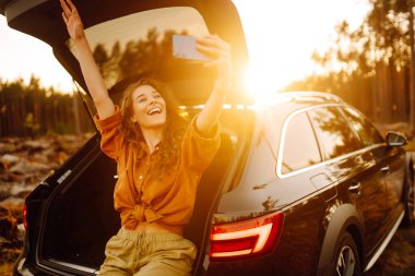 Arabayla seyahat ederken selfie. Video aracılığıyla mutlu turist sohbetleri ya da arabanın arka koltuğunda selfie çekmeler. Arabayla seyahat etme kavramı, aktif yaşam tarzı.