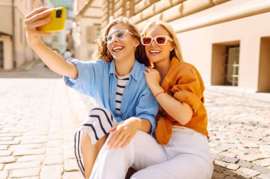 Bir turistin kadını akıllı telefon kamerasıyla sokaklarda dolaşıyor ve selfie çekiyor. Yaşam tarzı, seyahat, turizm, aktif yaşam.