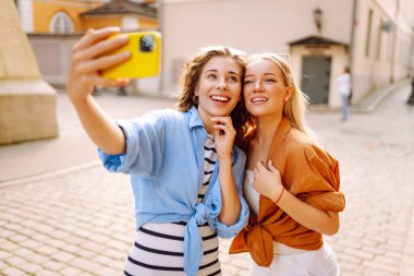 Bir turistin kadını akıllı telefon kamerasıyla sokaklarda dolaşıyor ve selfie çekiyor. Yaşam tarzı, seyahat, turizm, aktif yaşam.