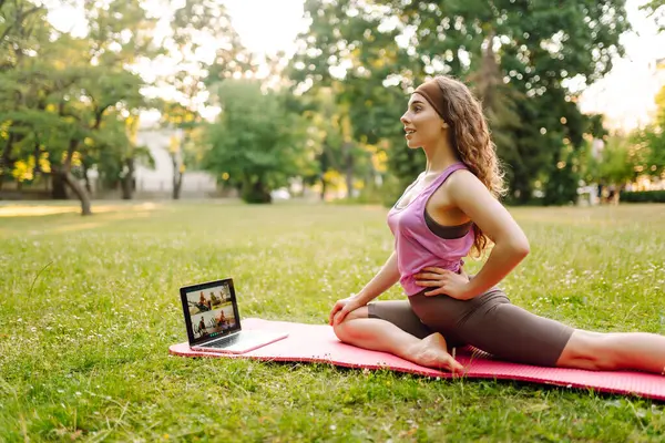 여자는 노트북과 공원에서 연습을 따릅니다 온라인 라이프 스타일 스포츠 스톡 이미지