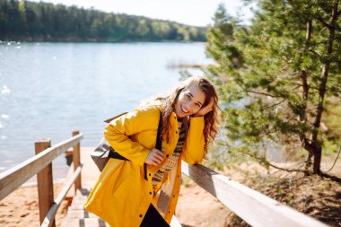 Ormanda dolaşırken gülümseyen mutlu kadın. Gezgin doğanın tadını çıkarıyor. Hafta sonu, turizm, yürüyüş..