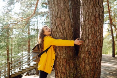 Ormanda dolaşırken gülümseyen mutlu kadın. Gezgin doğanın tadını çıkarıyor. Hafta sonu, turizm, yürüyüş..