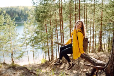 Ormanda dolaşırken gülümseyen mutlu kadın. Gezgin doğanın tadını çıkarıyor. Hafta sonu, turizm, yürüyüş..