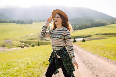 Gezgin doğanın tadını çıkarıyor. Güneşli dağlarda bir kadın. Yaşam tarzı, macera, doğa, aktif yaşam.