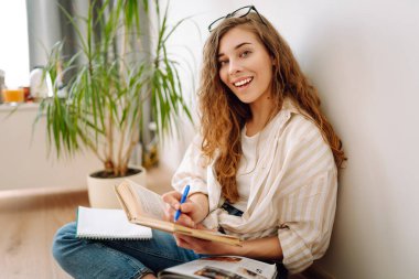 Kağıt defter günlüğü yazan genç kız öğrenci, notlar alıyor, çalışıyor, ödev yapıyor, kontrol listesi yapıyor. İş, blog yazma, serbest çalışma, eğitim kavramı.