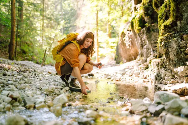 Mujer Saca Agua Manantial Limpia Del Arroyo Montaña Viaje Aventura Imagen de archivo