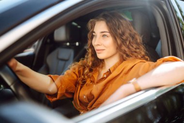 Araba süren genç bir kadın. Boş zaman, seyahat, hafta sonu, gezinti.