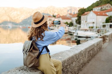 Güzel bir bayan turist sokaklarda yürüyor ve çekimlerin fotoğrafını çekiyor. Yaşam tarzı, seyahat, dinlenme, hafta sonu, aktif yaşam.