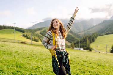 Sırt çantalı genç kadın doğa vadisine, dağlara ve sakin gündoğumuna bakıyor. Seyahat, doğa konsepti..