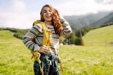 Sırt çantalı genç kadın doğa vadisine, dağlara ve sakin gündoğumuna bakıyor. Seyahat, doğa konsepti..