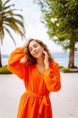 Palmiye ağaçlarının arkasındaki portre güzelliği modeli. Güneşli bir gün. Yaşam tarzı, moda, seyahat kavramı.