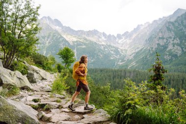 Başarılı bir turistin dağdaki portresi ve özgürlüğün tadını çıkarıyor. Yürüyüş kavramı, aktif yaşam tarzı. Maceralar