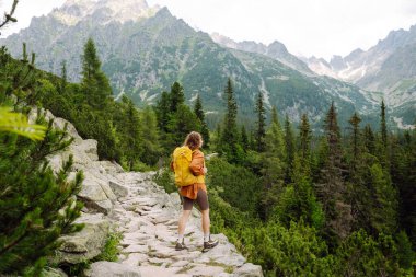 Başarılı bir turistin dağdaki portresi ve özgürlüğün tadını çıkarıyor. Yürüyüş kavramı, aktif yaşam tarzı. Maceralar