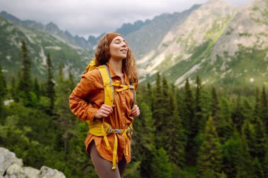 Başarılı bir turistin dağdaki portresi ve özgürlüğün tadını çıkarıyor. Yürüyüş kavramı, aktif yaşam tarzı. Maceralar
