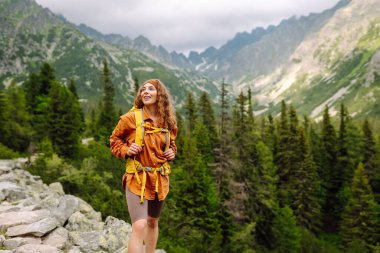 Başarılı bir turistin dağdaki portresi ve özgürlüğün tadını çıkarıyor. Yürüyüş kavramı, aktif yaşam tarzı. Maceralar