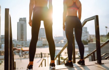 İki kadın birlikte dışarıda spor yapıyorlar. Sabah yoğun bir antrenmandan önce kaslarını ısıtıyorum. Spor, aktif yaşam, spor eğitimi, sağlıklı yaşam tarzı..