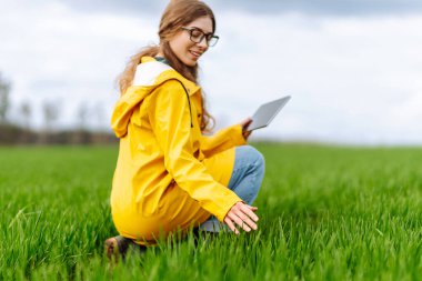 Yenilikçi akıllı tarım sistemi teknolojisi, tarım yönetimi. Yeşil tarlada modern tabletli kadın çiftçi.. 