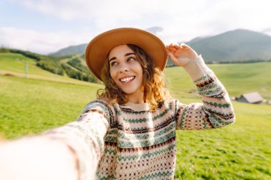 Doğada selfie çeken güzel bir genç kadın. Bloglama, iletişim, seyahat, turizm, doğa, aktif yaşam.