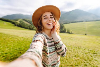 Doğada selfie çeken güzel bir genç kadın. Bloglama, iletişim, seyahat, turizm, doğa, aktif yaşam.