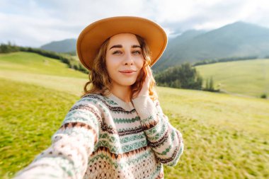 Doğada selfie çeken güzel bir genç kadın. Bloglama, iletişim, seyahat, turizm, doğa, aktif yaşam.