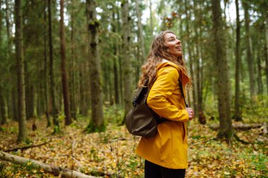 Mutlu bayan turist sonbahar ormanında yürüyor. Doğa. Seyahatler. Etkin yaşam biçimi.