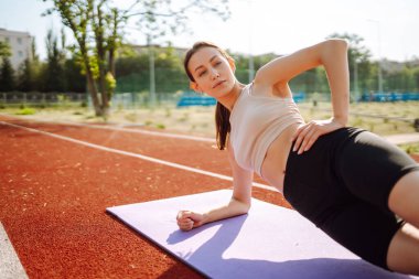 Genç ve güzel bir kadın spor alanında egzersiz yapıyor. Fitness. Etkin yaşam biçimi