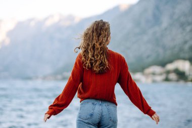 Dışarıdaki soğuk havada güzel, kıvırcık bir kadının portresi. Yaşam tarzı, moda, seyahat kavramı.