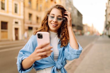 Sokakta cep telefonu kullanan güzel bir kadın. Gençlik konsepti. İş, teknoloji, blog, iletişim kavramı.
