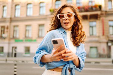 Sokakta cep telefonu kullanan güzel bir kadın. Gençlik konsepti. İş, teknoloji, blog, iletişim kavramı.