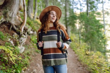 Ormandaki patikada sırt çantalı bir kadın turist. Seyahatler. Etkin yaşam biçimi.