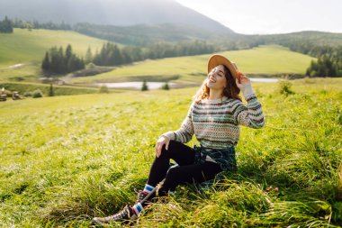 Bir dağ vadisinde seyahat eden genç ve çekici bir kız yolcunun portresi. Macera, seyahat konsepti.